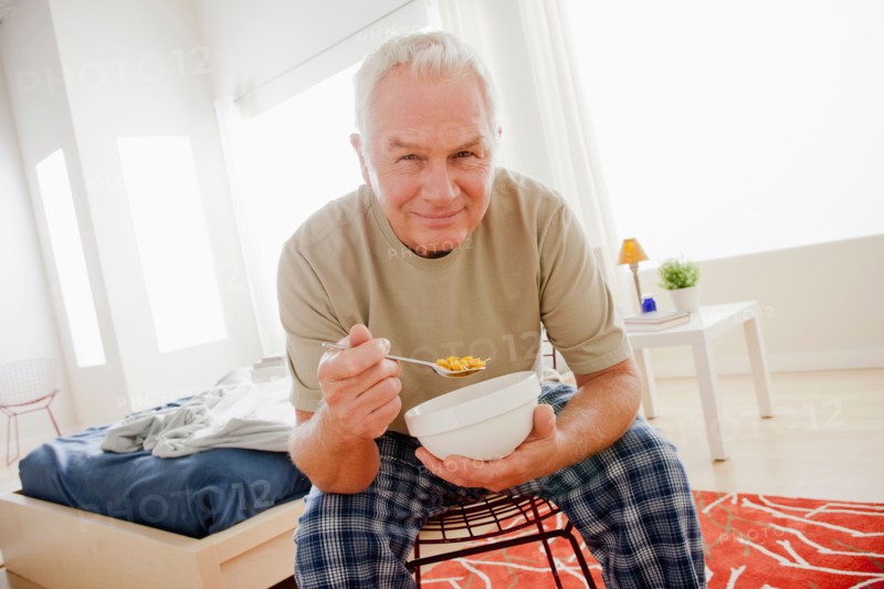 Senior man eating cereal from bowl. Photo : Rob Lewine