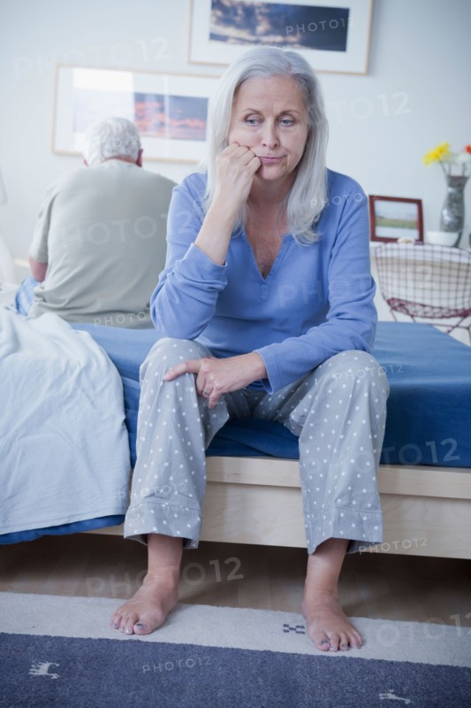 Senior couple after quarrel sitting on bed. Photo: Rob Lewine
