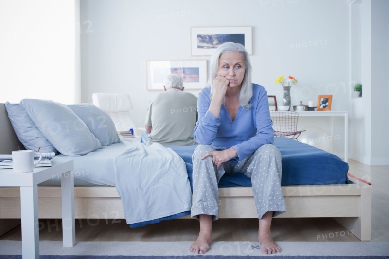 Senior couple after quarrel sitting on bed. Photo: Rob Lewine