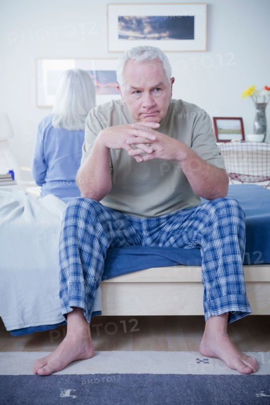 Senior couple after quarrel sitting on bed. Photo : Rob Lewine