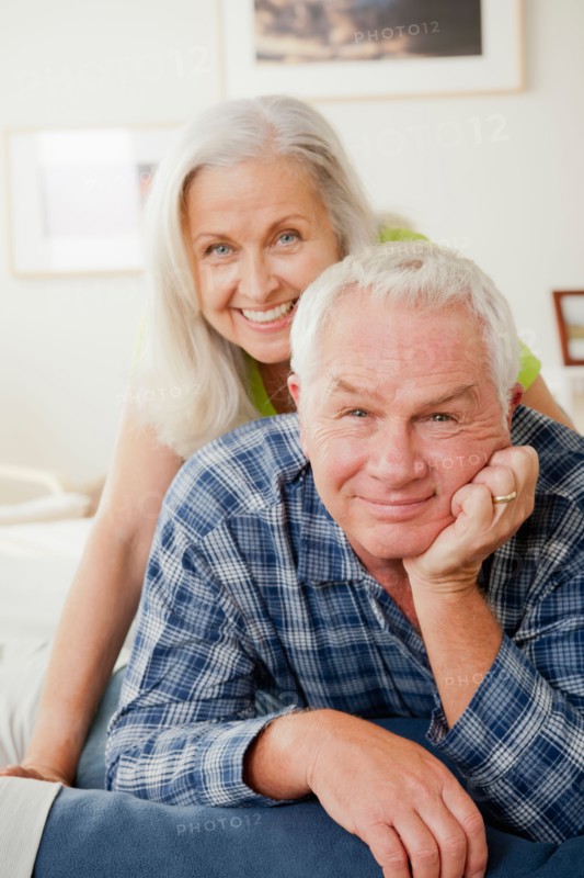 Portrait of senior couple laying on bed. Photo : Rob Lewine