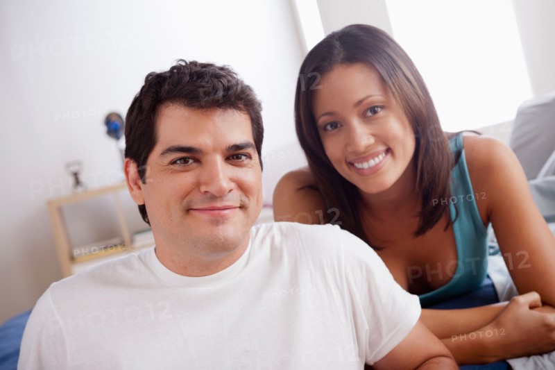Portrait of mid adult couple in bedroom. Photo: Rob Lewine
