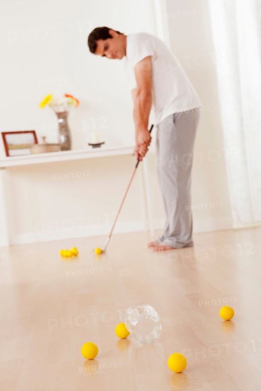 Man dressed in pajamas playing mini golf at home. Photo: Rob Lewine