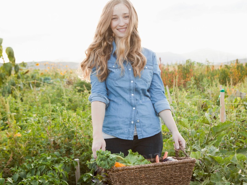 Portrait of young woman harvesting vegetables. Photo : Jessica Peterson