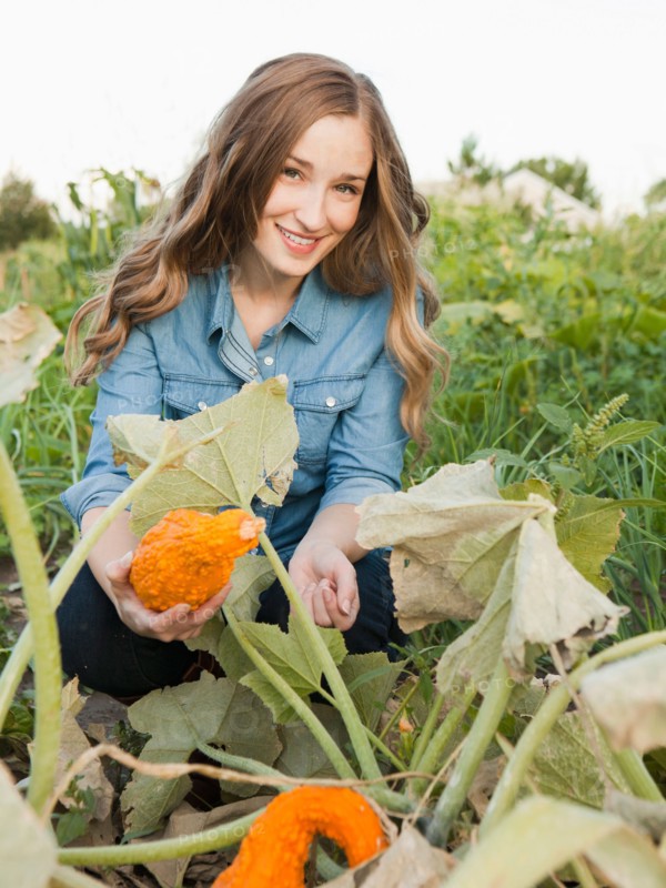 Portrait of young woman harvesting squash. Photo: Jessica Peterson