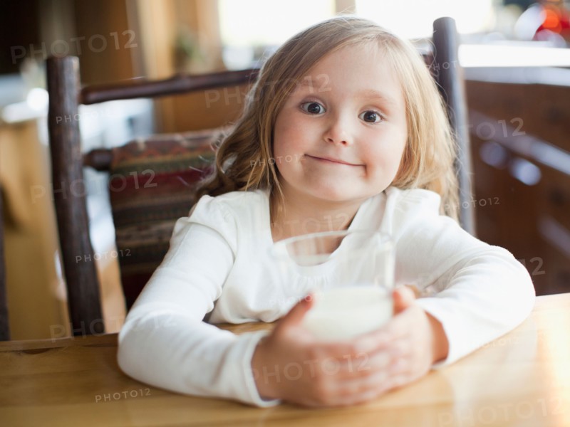 Girl (4-5) drinking milk in kitchen. Photo : Jessica Peterson