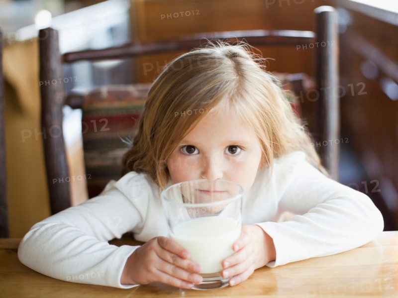 Girl (4-5) drinking milk in kitchen. Photo : Jessica Peterson