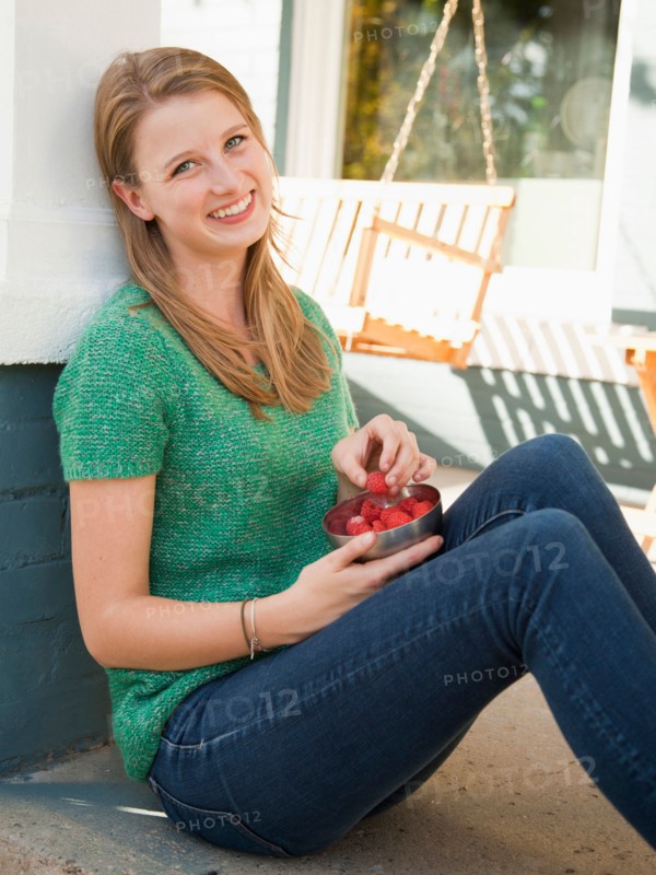 Portrait of young woman eating raspberries. Photo : Jessica Peterson