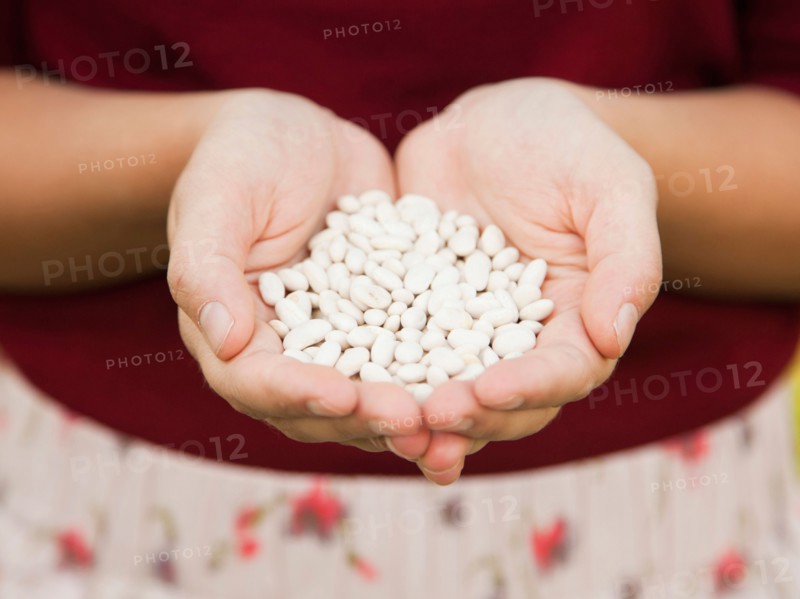 Mid-section of woman holding white beans. Photo: Jessica Peterson