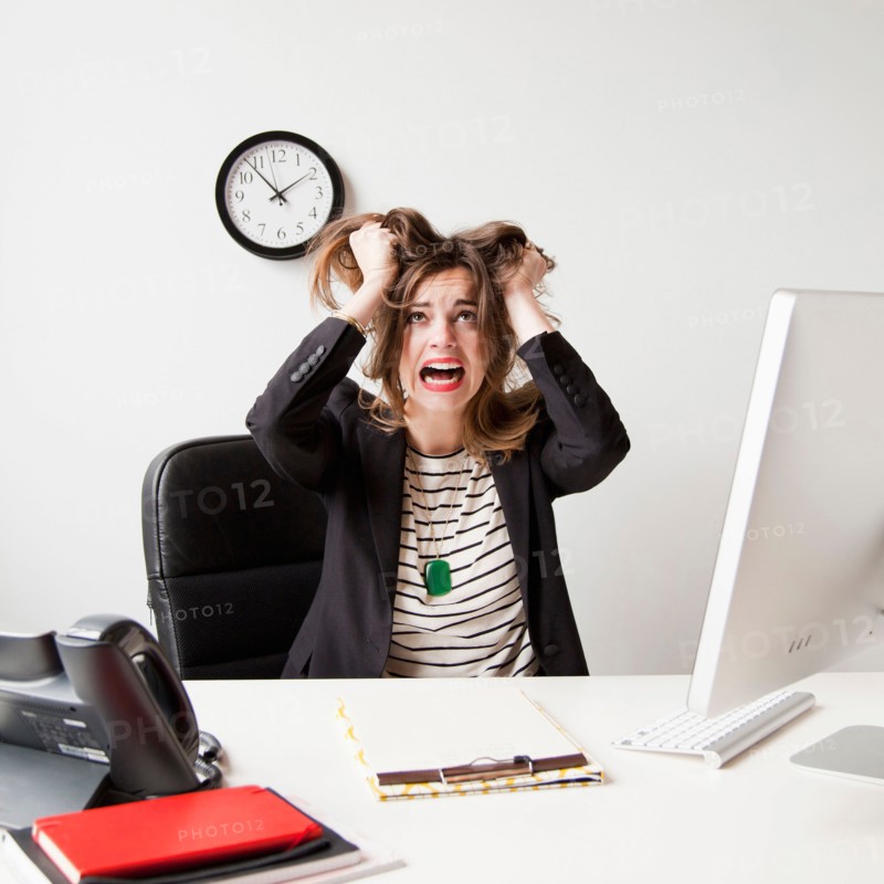 Studio shot of young woman working in office and tearing her hair out. Photo: Jessica Peterson