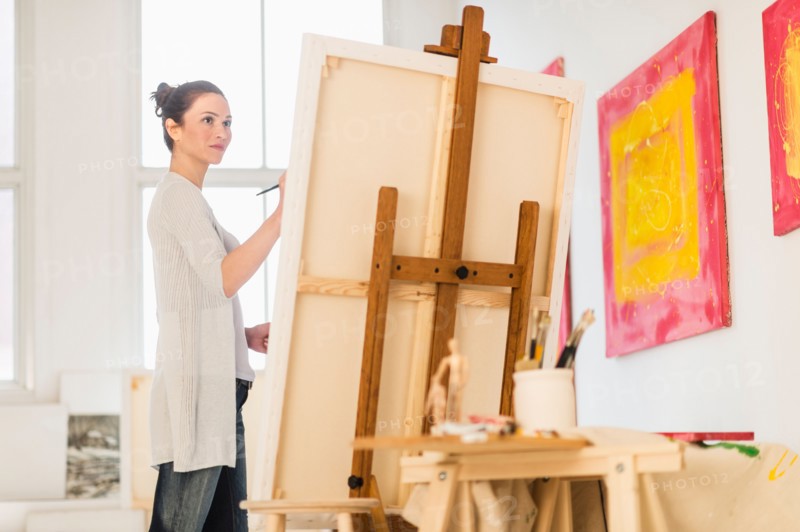 Woman painting at easel.