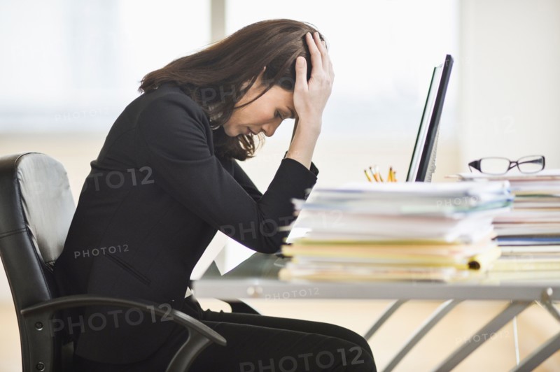 Businesswoman with head in hands.