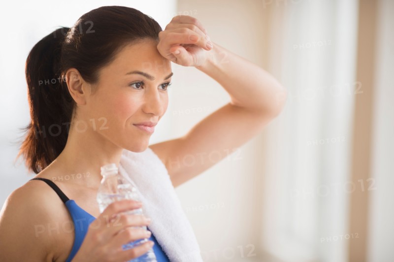 Woman drinking water in gym.