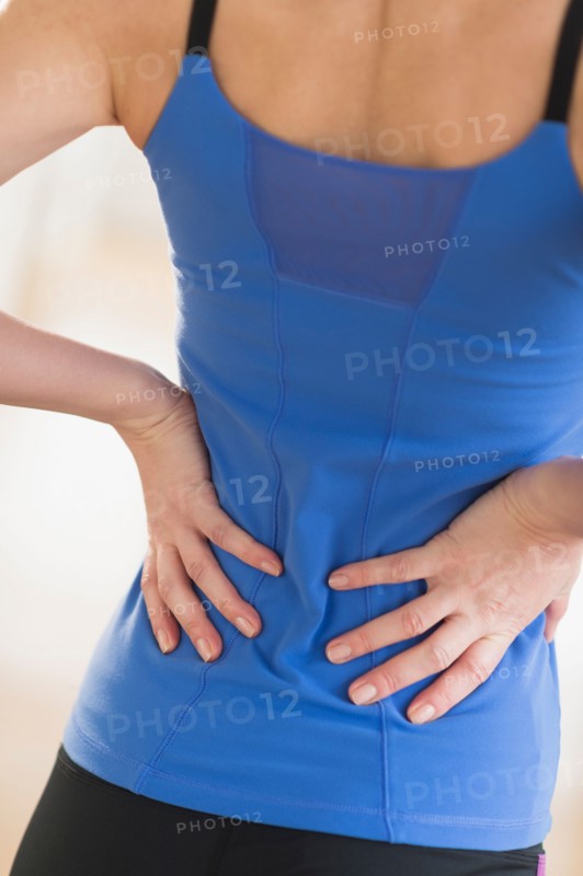 Midsection of woman with hands on back.
