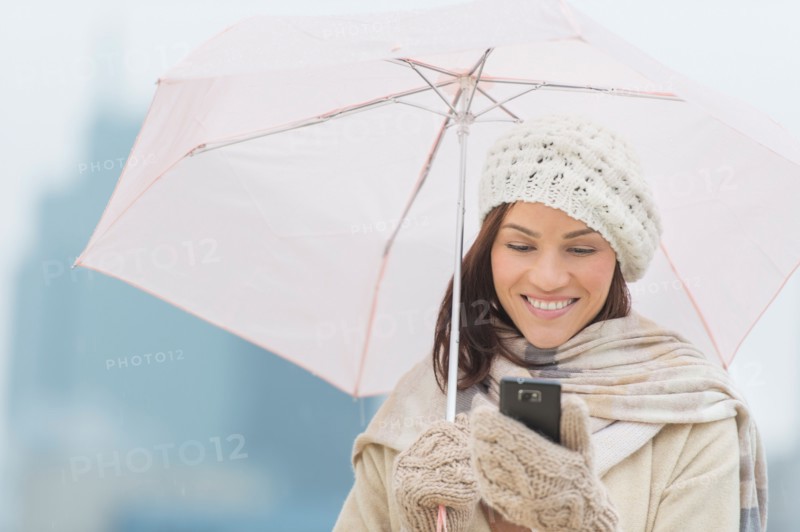 Woman with umbrella using phone.