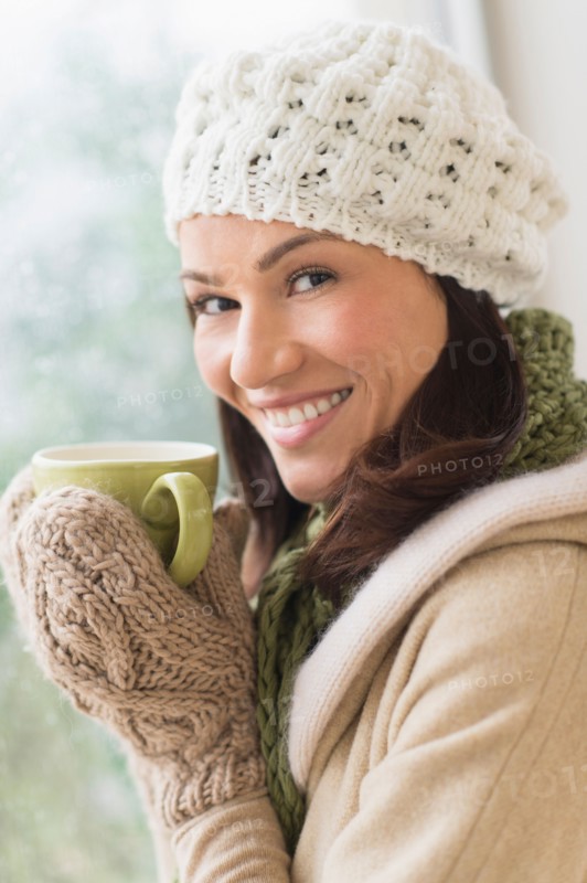 Portrait of woman in warm clothes holding mug.