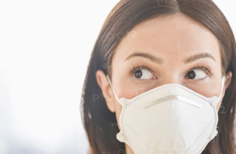 Studio portrait of woman wearing flu mask.