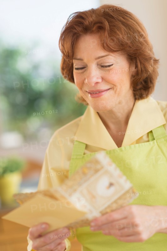 Senior woman reading greeting card.