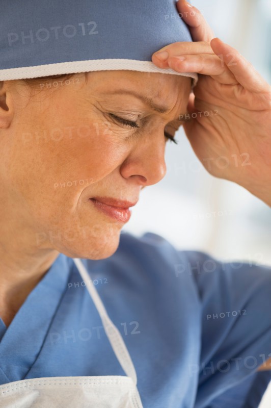 Female surgeon suffering headache.