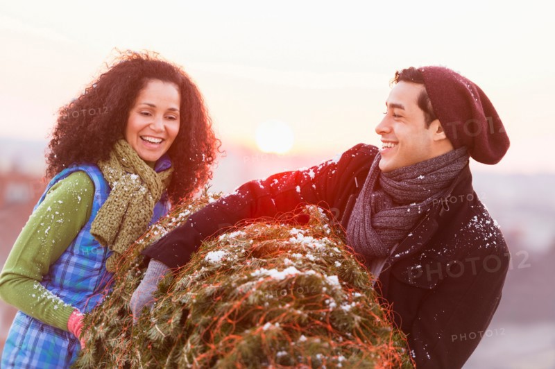 Couple carrying christmas tree.