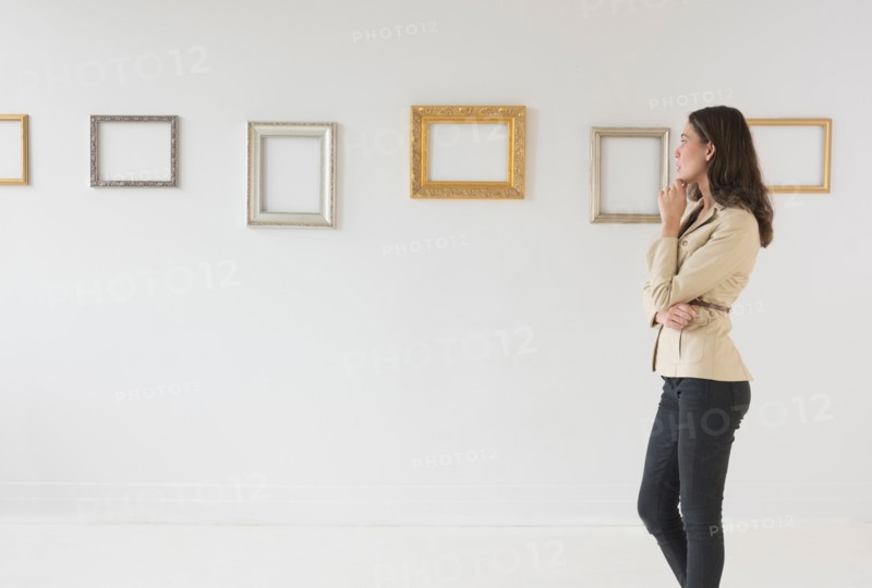 Woman looking at blank pictures in art gallery.
