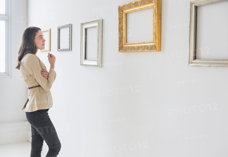 Woman looking at blank pictures in art gallery.