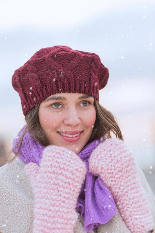 Portrait of young woman wearing knit hat, gloves and scarf.
