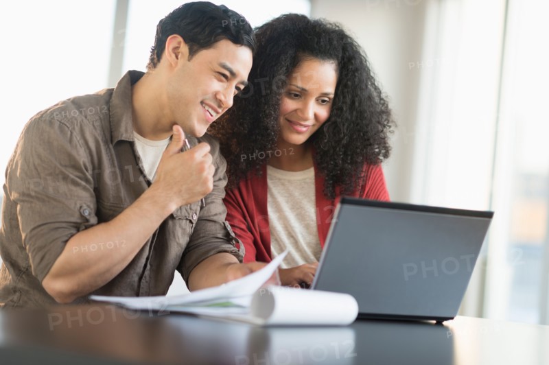Smiling couple planning home ownership with model home.