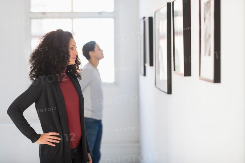 Visitors looking at artworks in gallery.