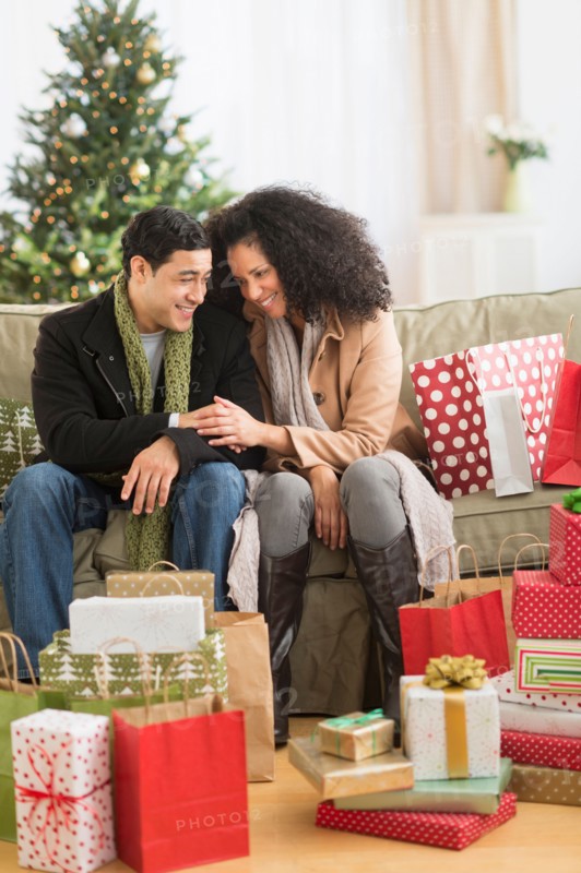 Couple with Christmas presents in living room.