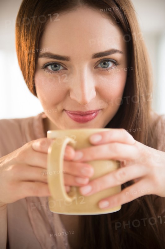Portrait of young woman holding coffee cup