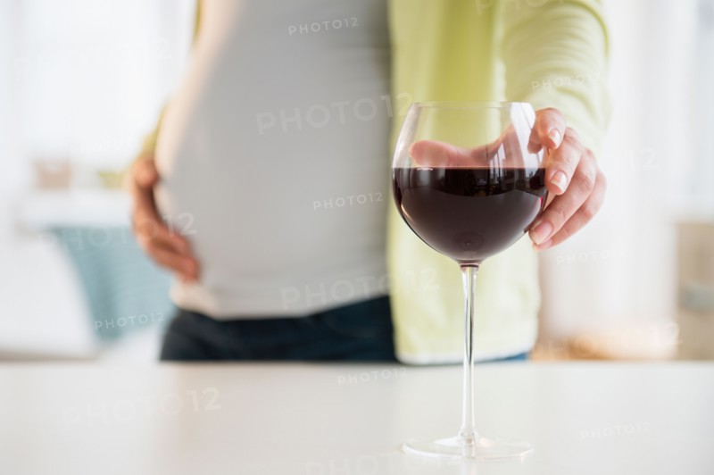 Pregnant woman with glass of red wine