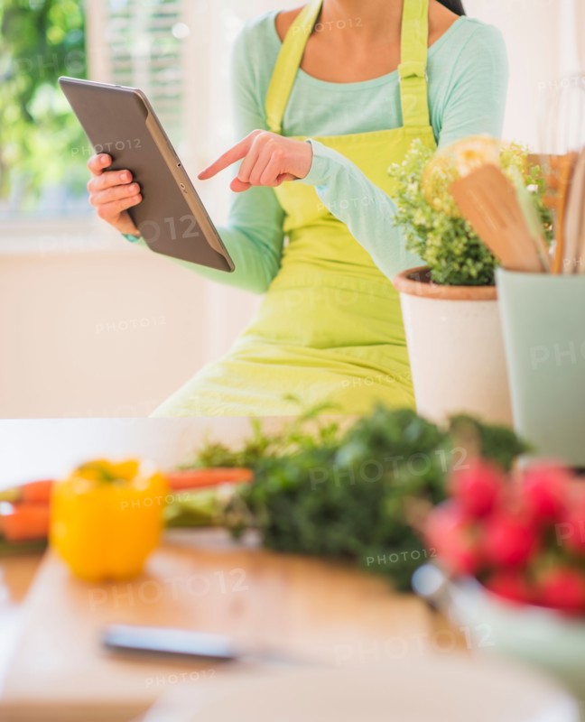 Teenage girl using digital tablet in kitchen