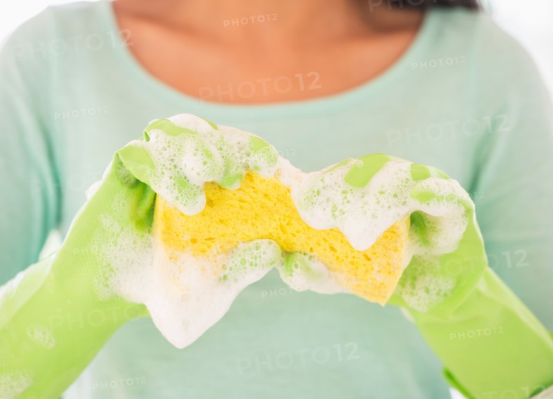 Teenage girl wearing rubber gloves with washing sponge