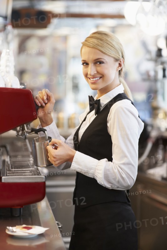 Female barista steaming milk