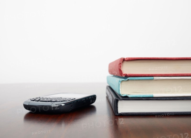 Mobile phone beside stack of books