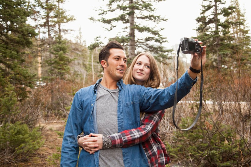 Young couple self photographing in non-urban scene