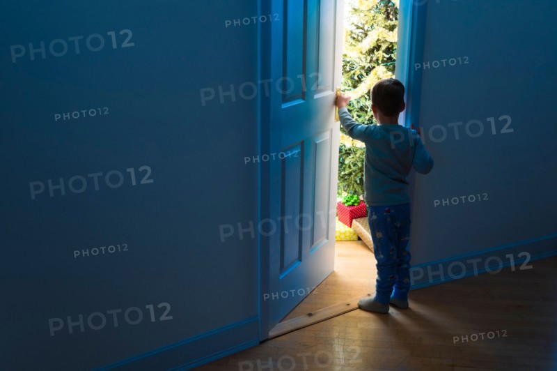 Boy (4-5) peeking through doorway.