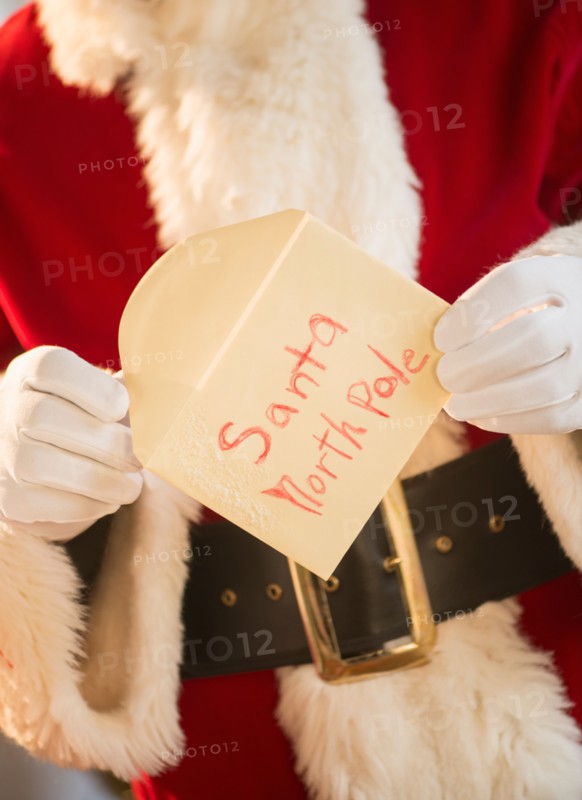 Santa claus holding letter.