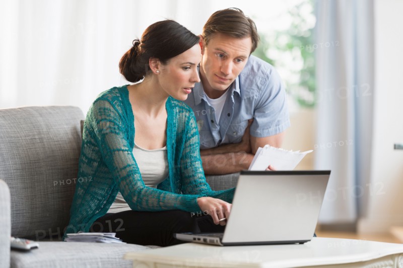 Couple using laptop together to pay bills.