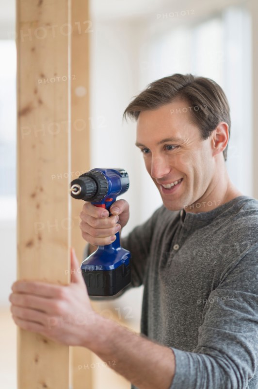 Man using hand drill.