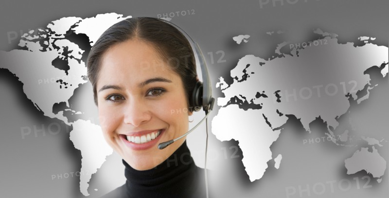 Woman with headset with world map in background.