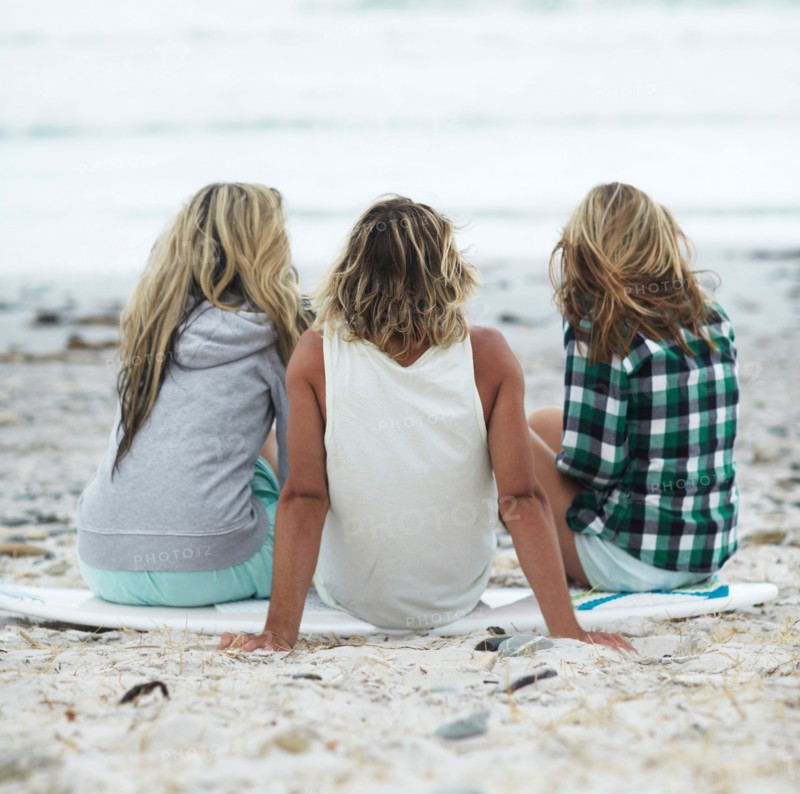 Rear view of people sitting on beach