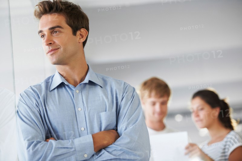 Portrait of man with coworkers in background