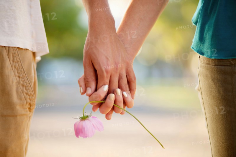 Couple holding hands and flower