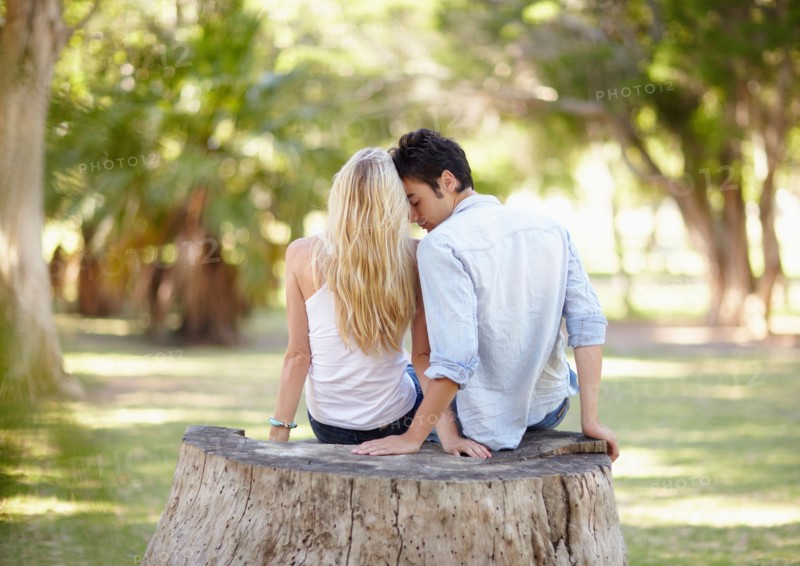 Couple sitting on tree stump