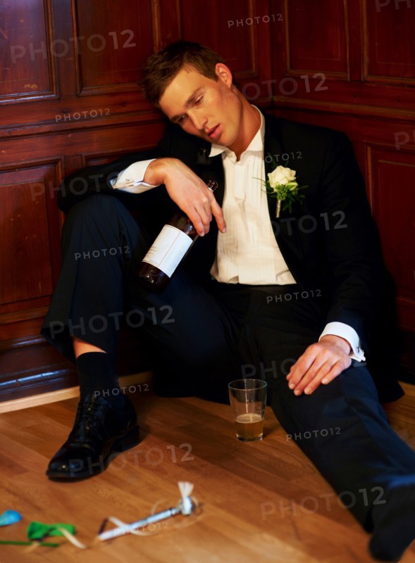 Drunk groom sitting on floor