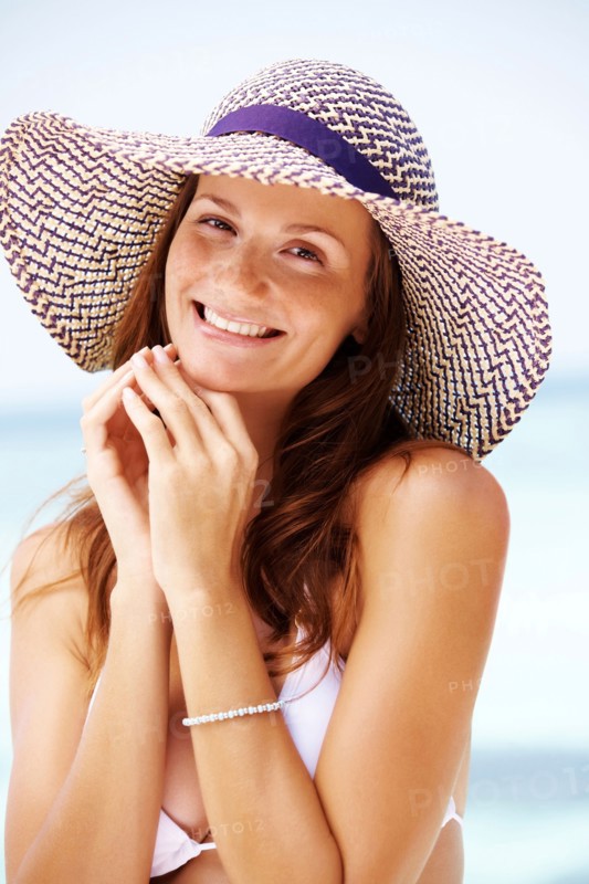 Portrait of young woman in bikini and straw hat