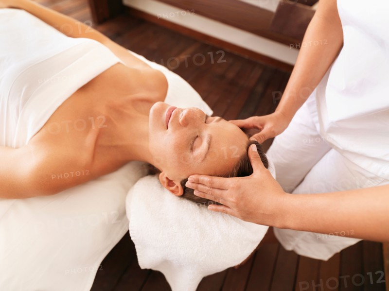 Woman getting facial massage in spa