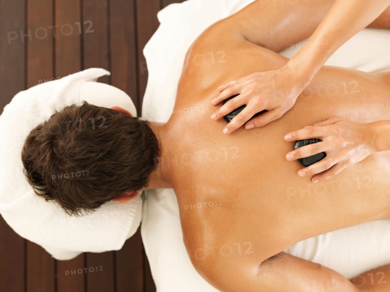 Man getting stone massage in spa